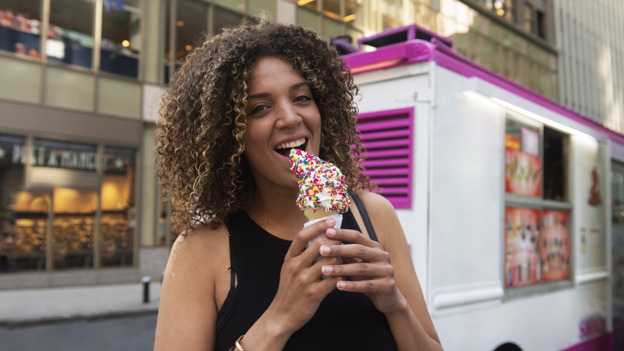 Kobieta je lody z food trucka.